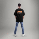 Black oversized t-shirt featuring a vintage Ford Mustang graphic on the back with an orange grunge background – worn by a male model facing away.